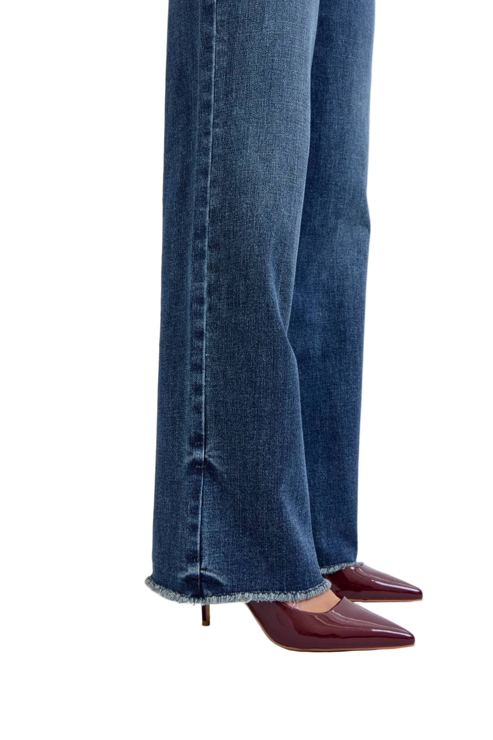 Close-up of blue jeans and maroon shoes on a light gray background