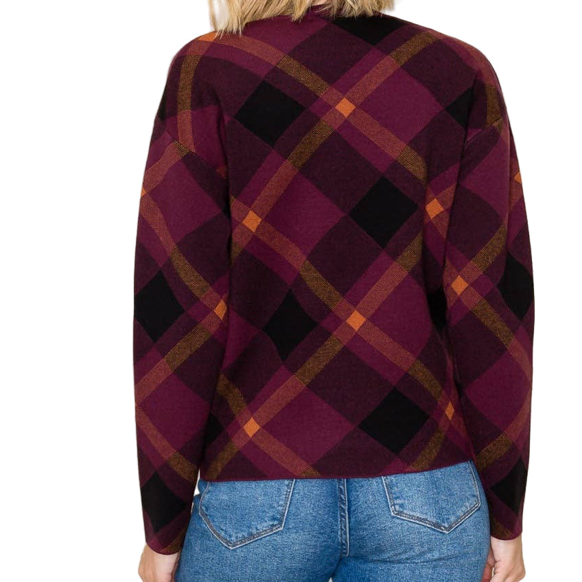 Person wearing a plaid shirt and blue jeans against a plain background