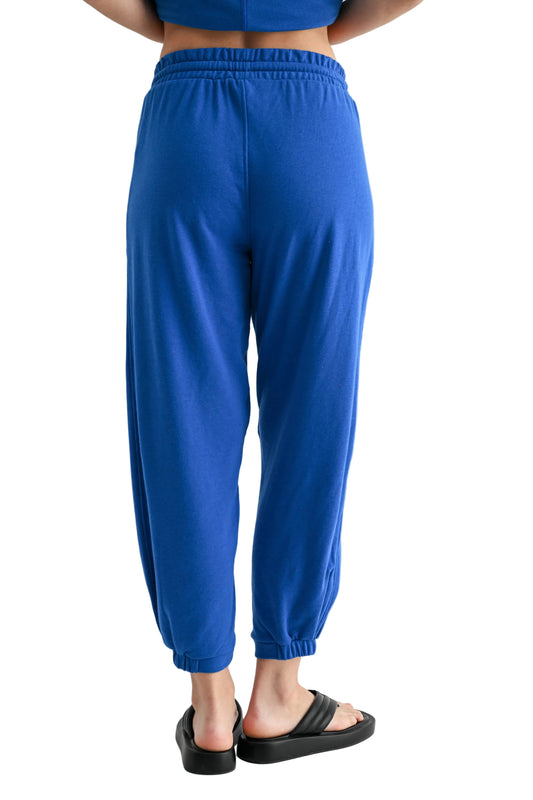 Person wearing blue sweatpants on a light gray background