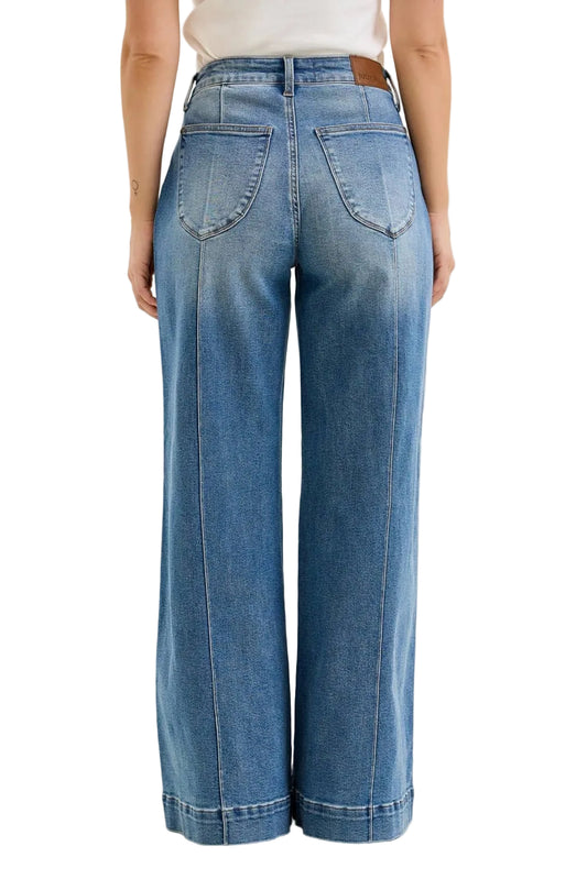 Blue jeans worn by a person on a beige background