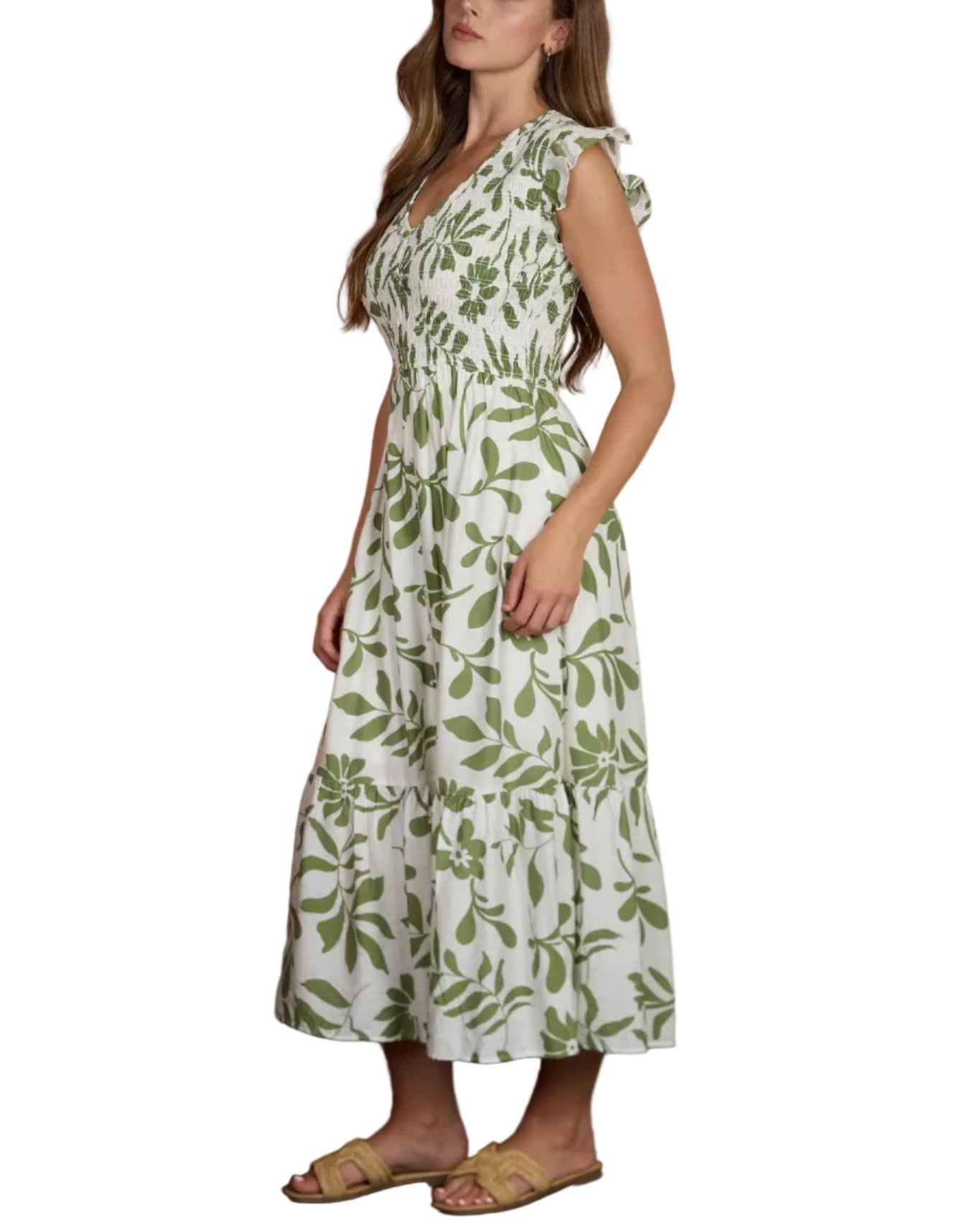 Woman wearing a green leaf-patterned dress standing against a blurred background