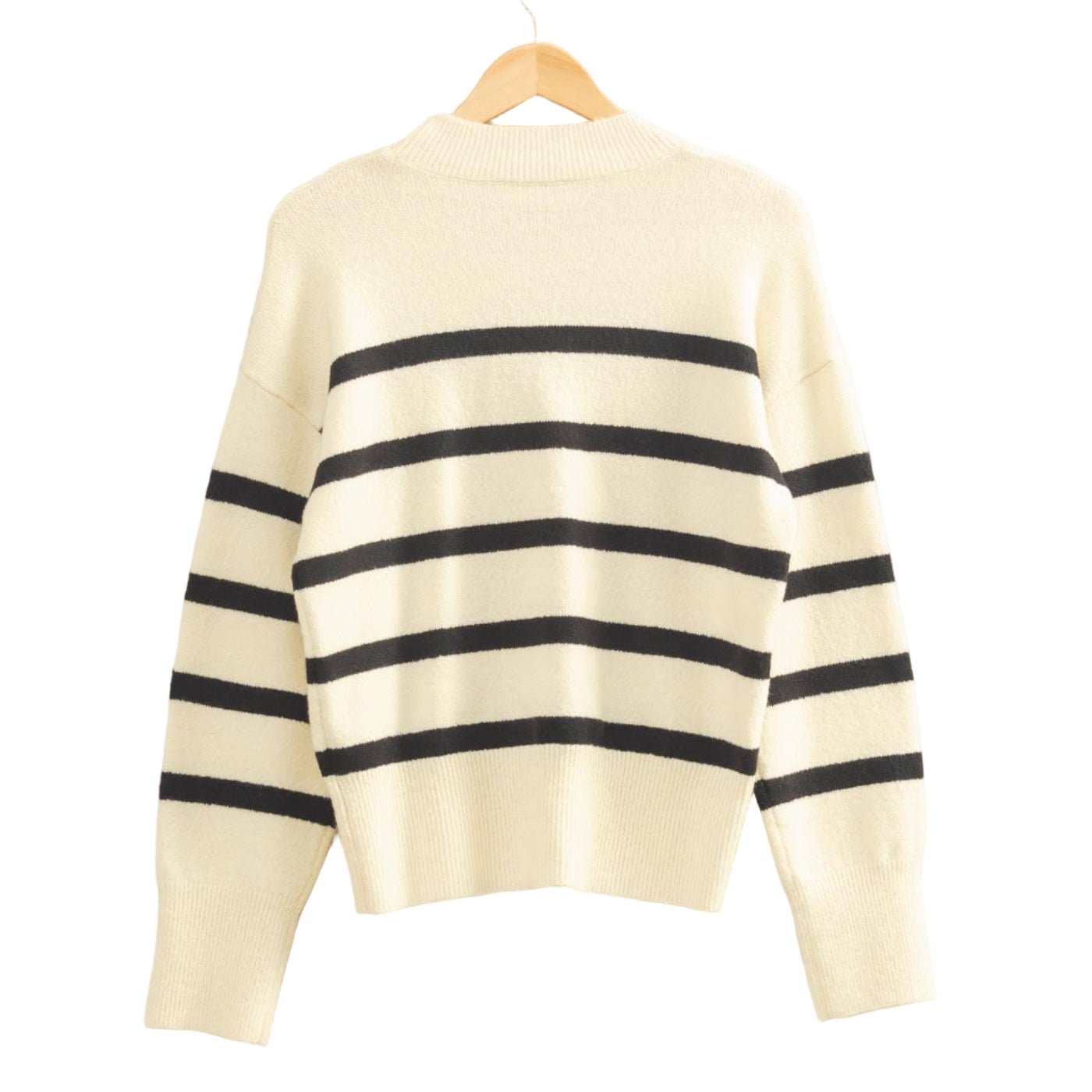 White sweater with black stripes on a hanger against a light background