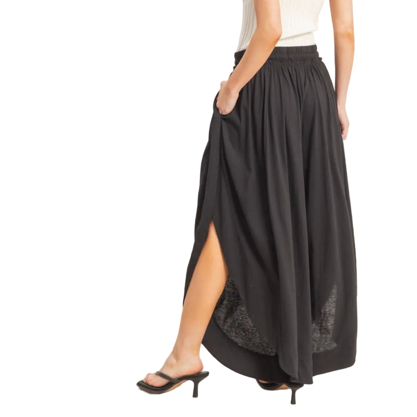 Woman wearing a black skirt with a white top on a plain background
