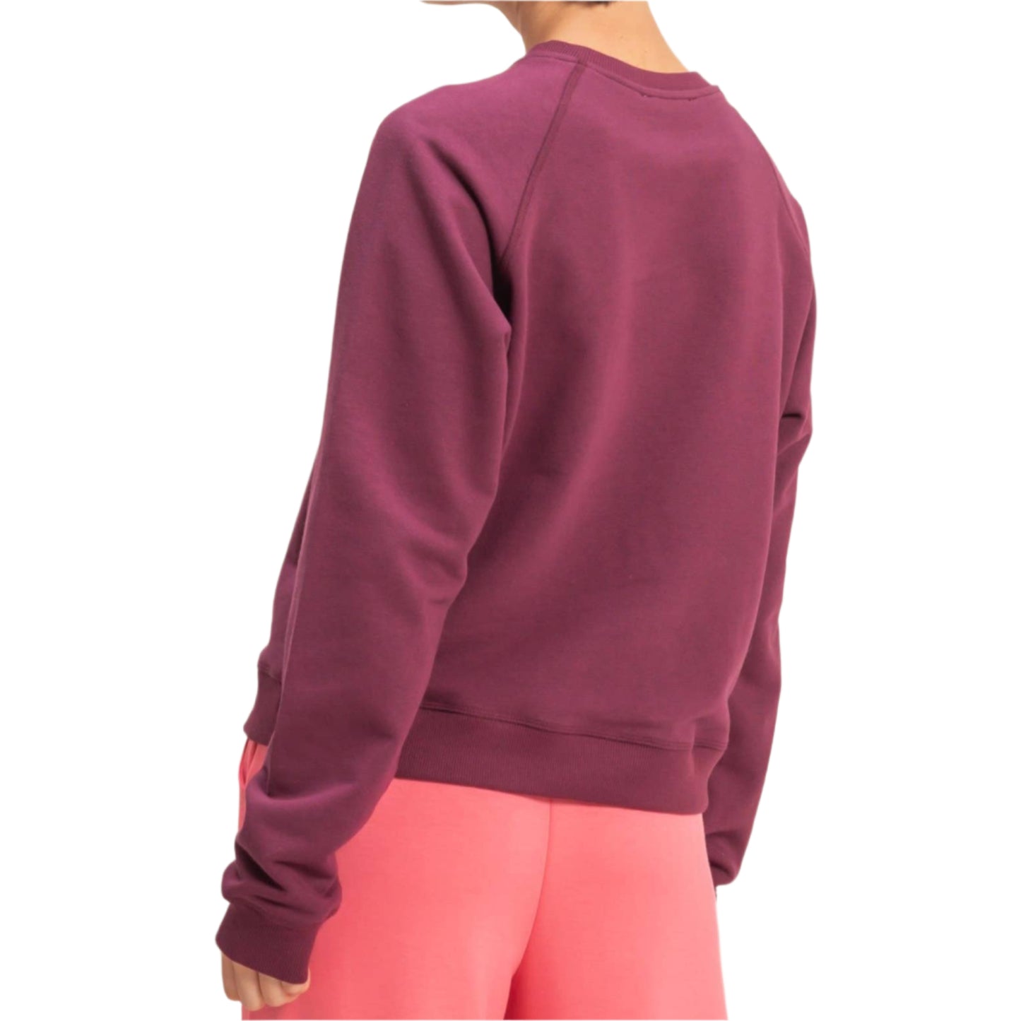 Person wearing a maroon sweatshirt and pink pants on a beige background