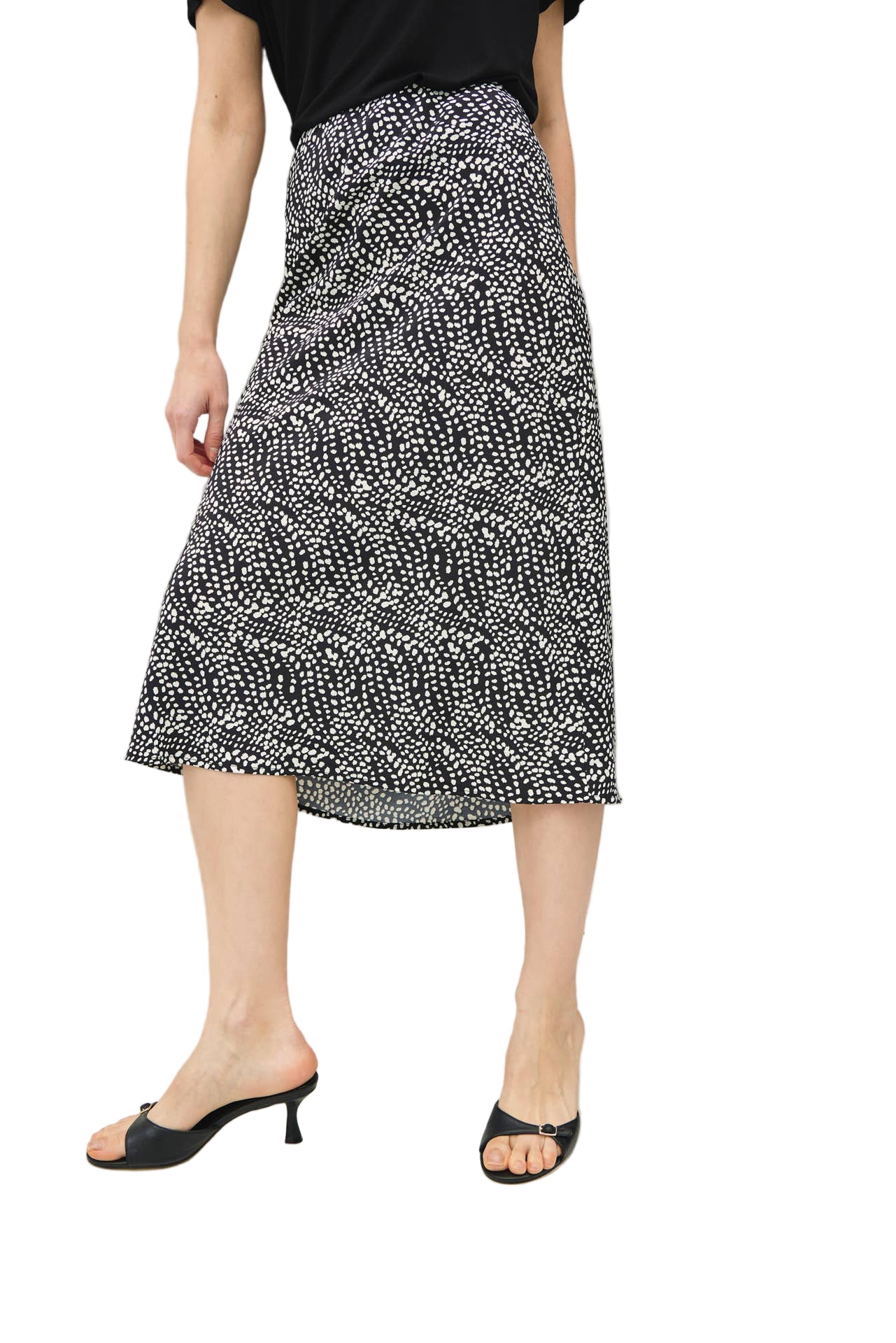 Person wearing a black and white patterned skirt on a plain background