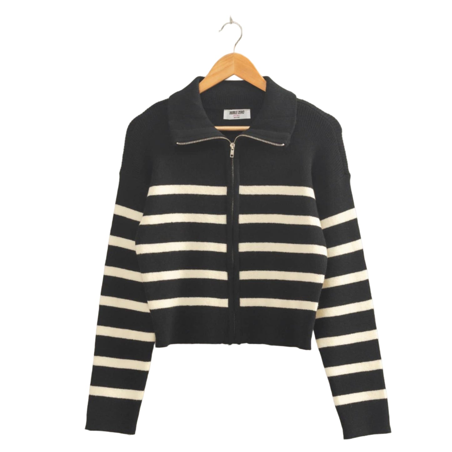 Black and white striped sweater on a hanger against a beige wall