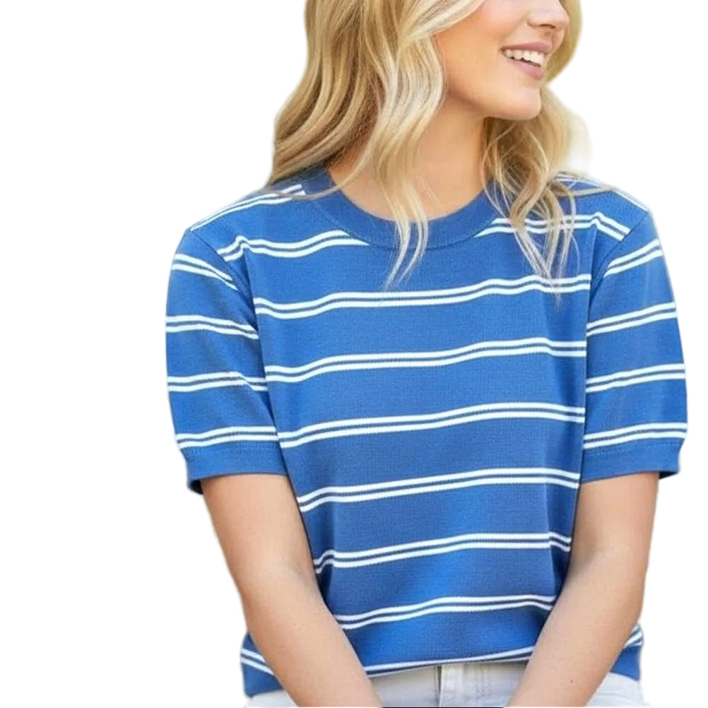 Woman wearing a blue and white striped shirt sitting outdoors.