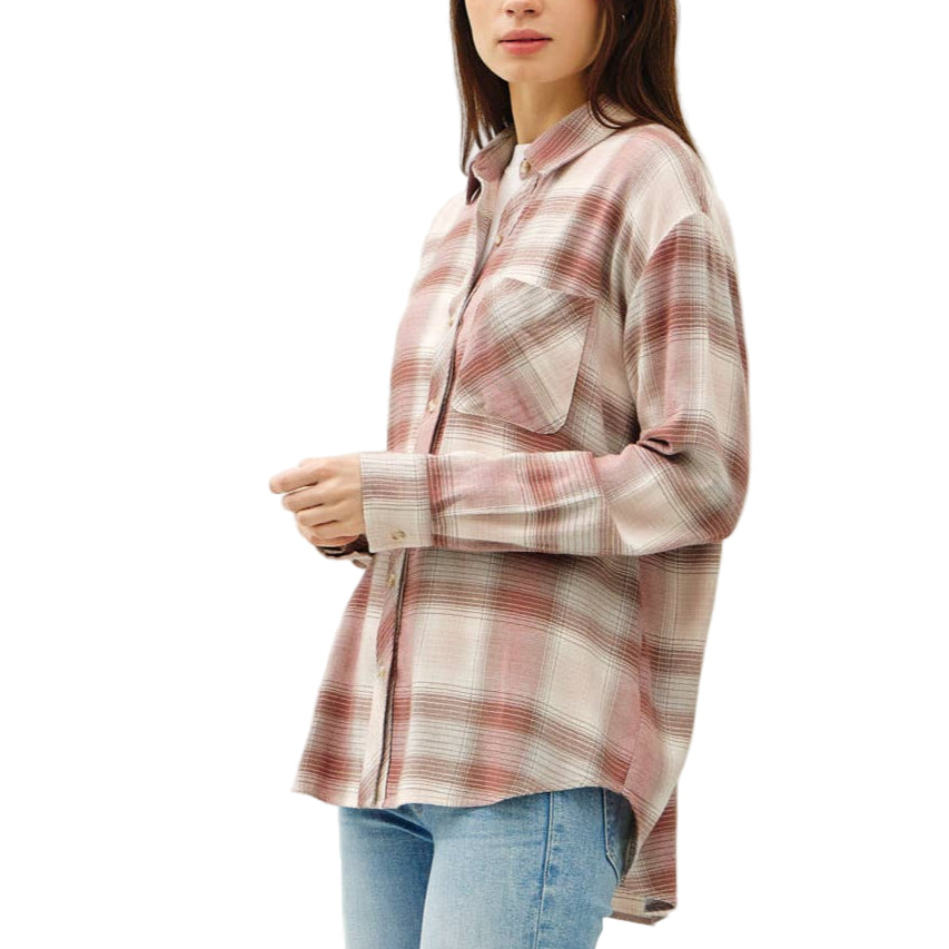 Person wearing a plaid shirt, light blue jeans, and white sneakers on a white background