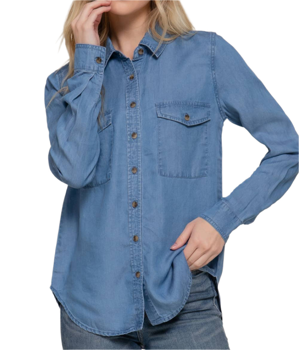 Woman wearing a blue denim shirt against a plain background