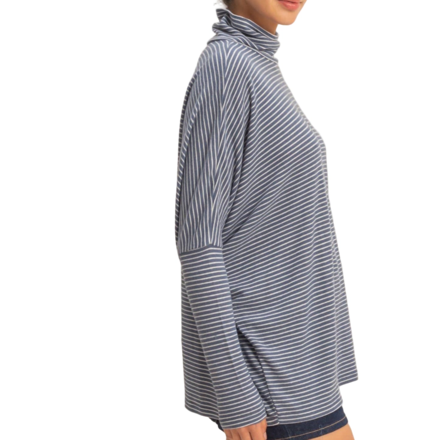 Woman wearing a blue and white striped long-sleeve top against a beige background