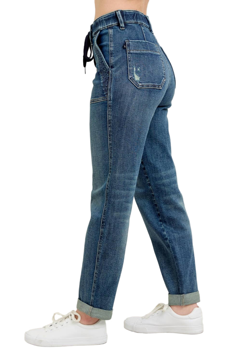 Blue jeans worn by a person on a beige background
