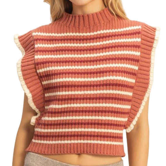 Woman wearing a striped red and white top and beige pants on a plain background