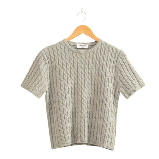 Gray textured sweater on a hanger against a beige background