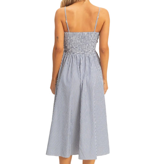 Woman wearing a blue and white striped dress on a plain background