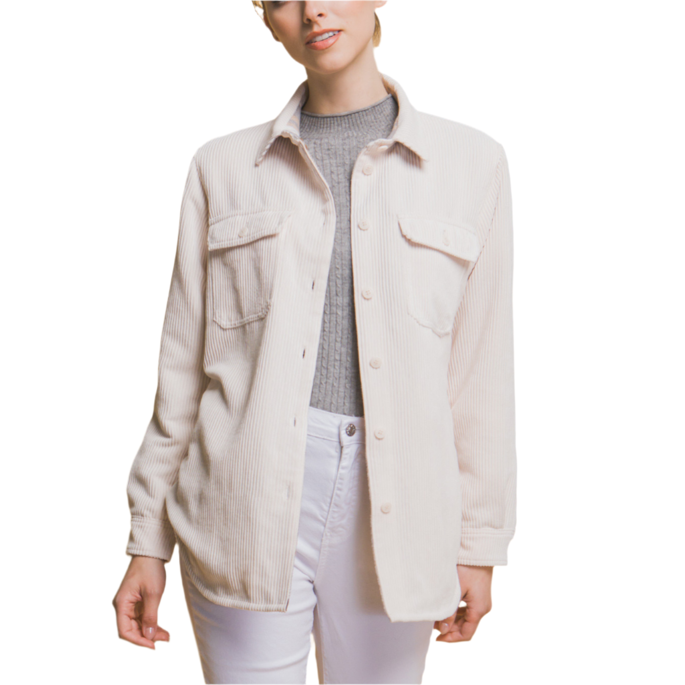 Woman wearing a beige jacket, gray sweater, and white pants against a beige background