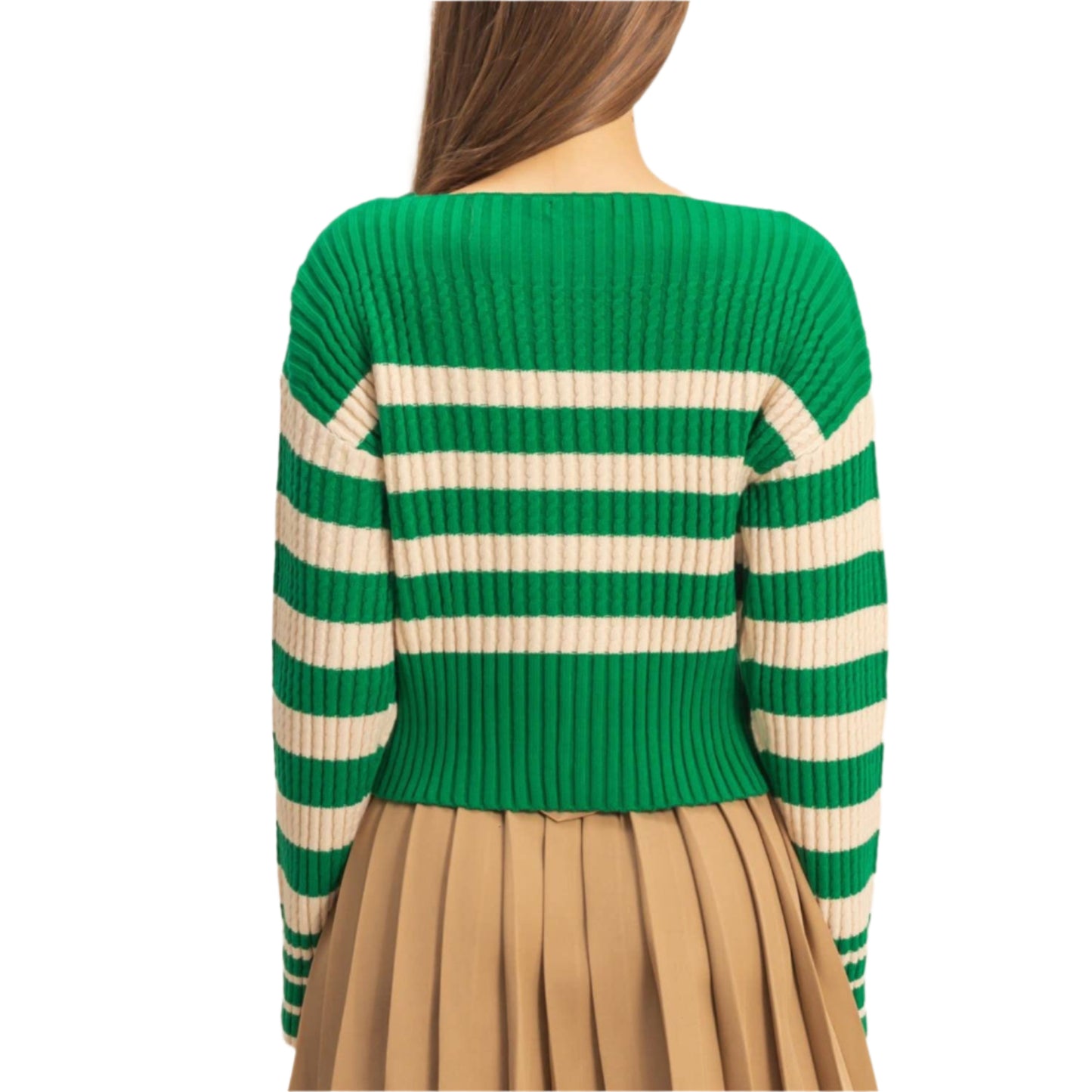 Person wearing a green and beige striped sweater with a beige pleated skirt on a beige background