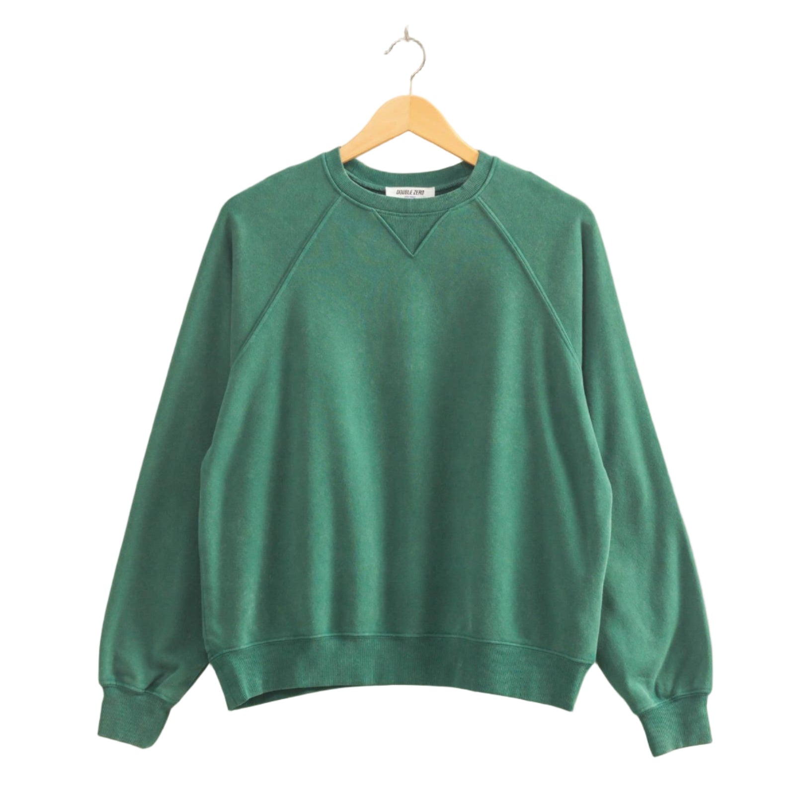 Green sweatshirt on a wooden hanger against a beige wall