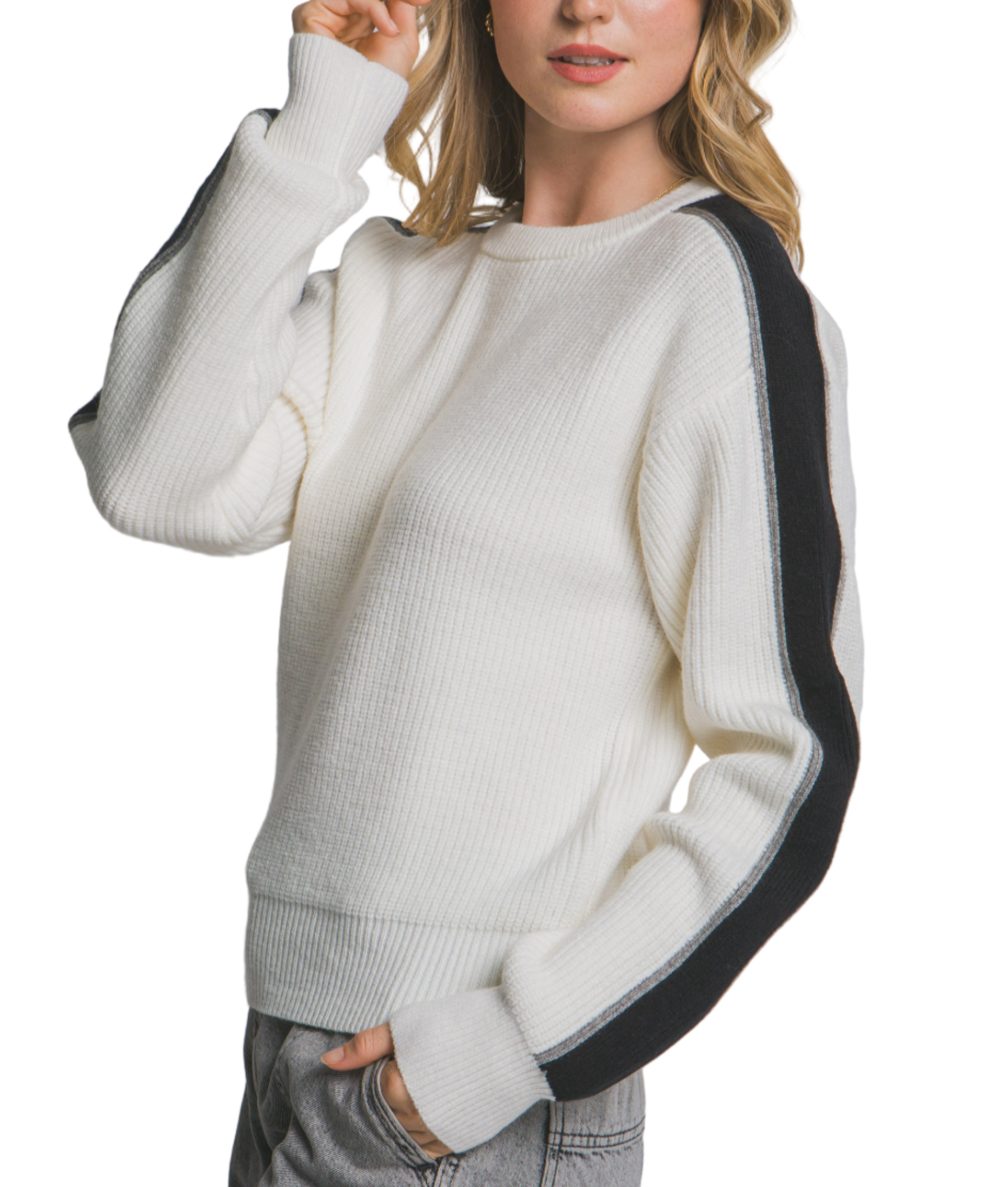 Woman wearing a white sweater with black sleeves against a plain background