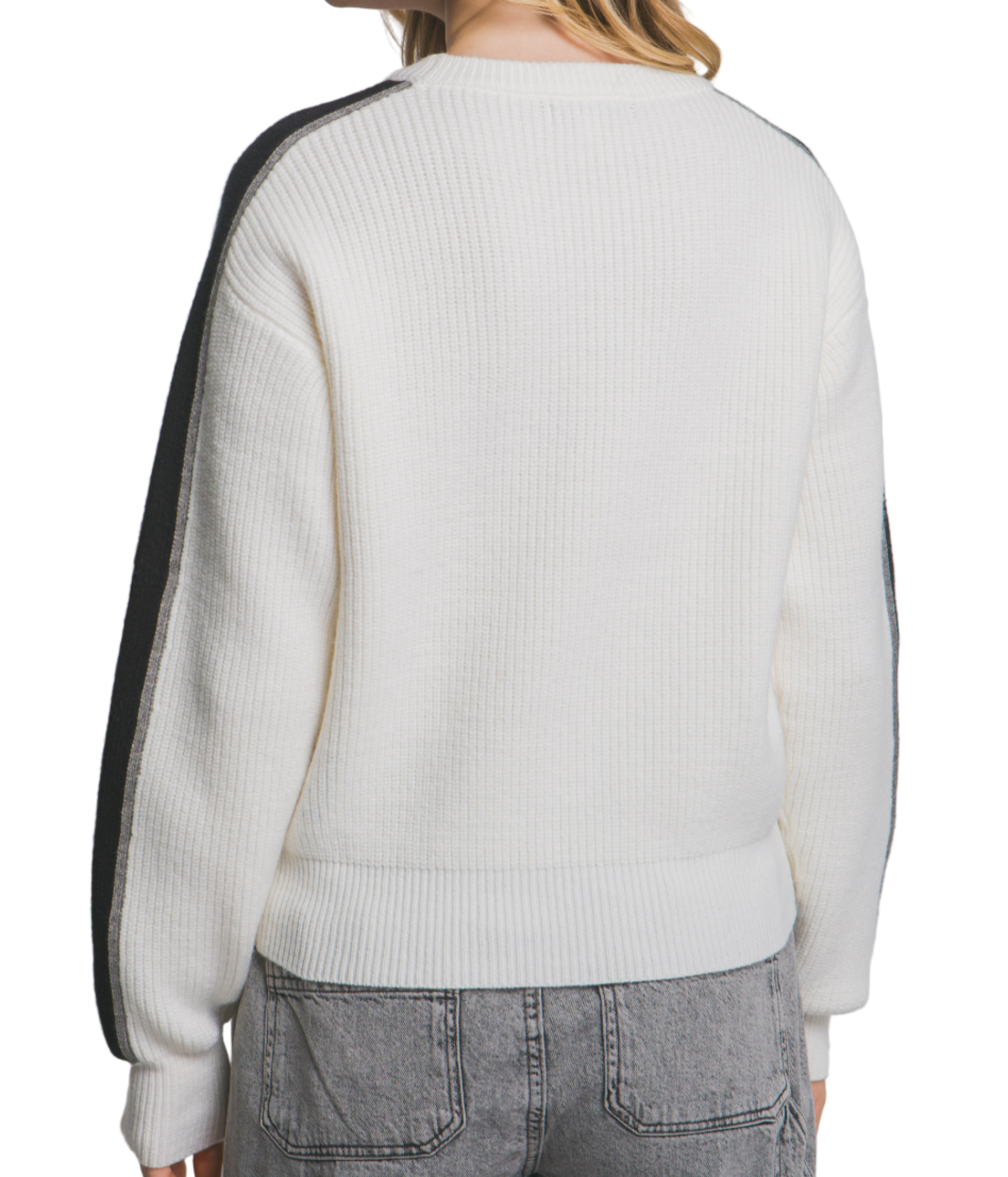 Person wearing a white sweater with black accents on a plain background