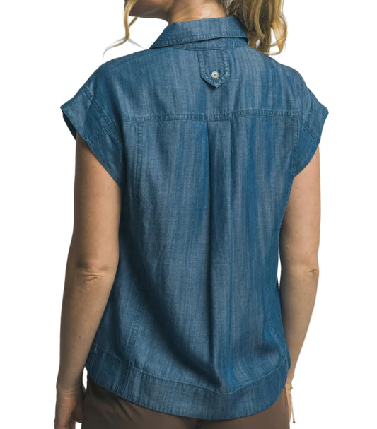 Woman wearing a blue denim shirt against a plain background