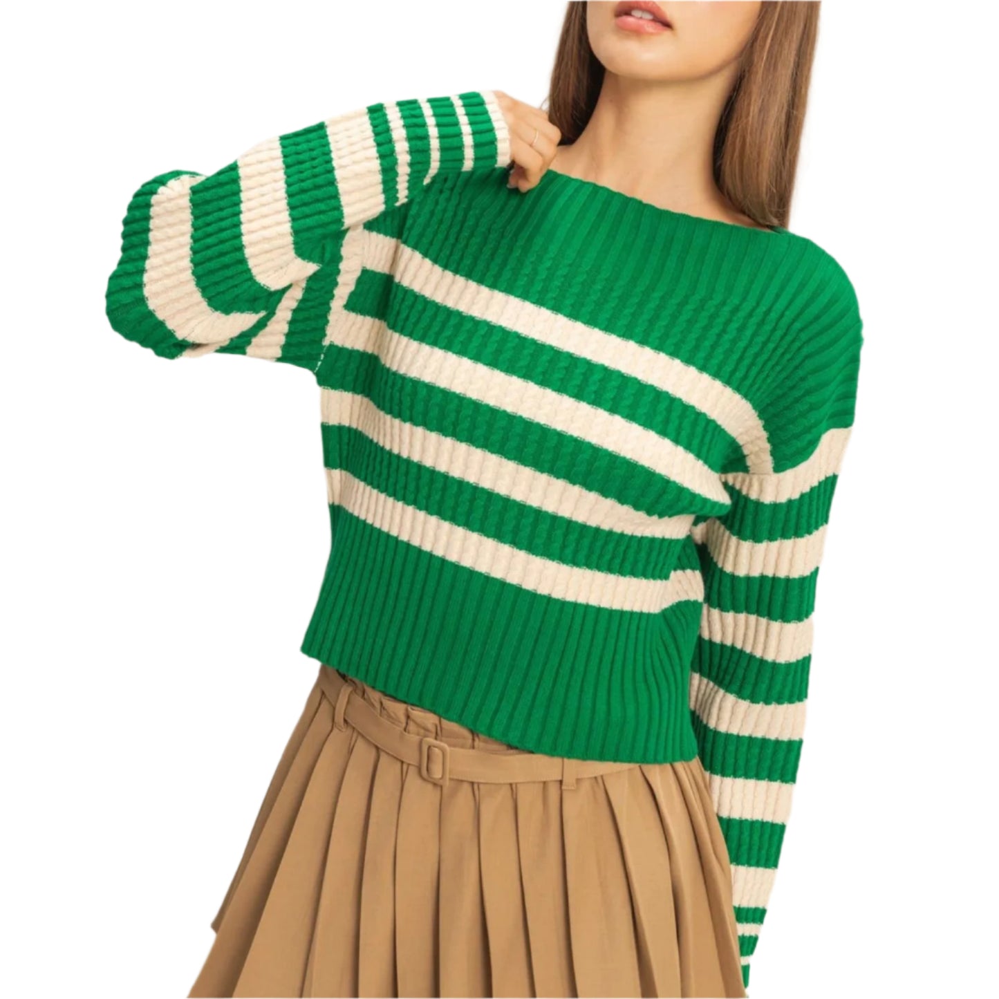 Woman wearing a green and white striped sweater with a beige pleated skirt on a plain background