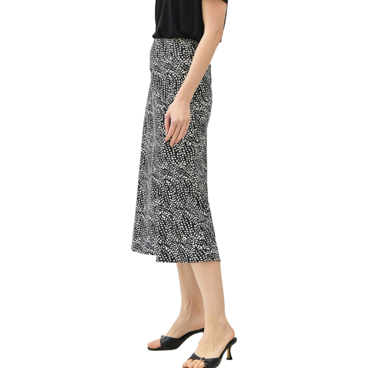 Woman wearing a black top and patterned skirt on a white background