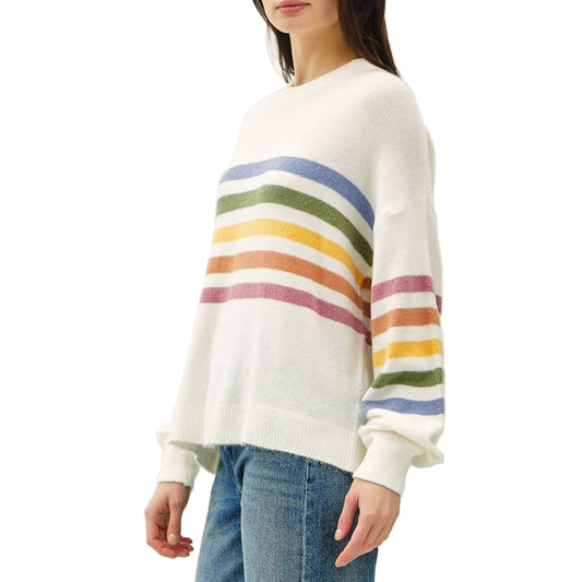 Person wearing a white sweater with rainbow stripes and blue jeans on a white background