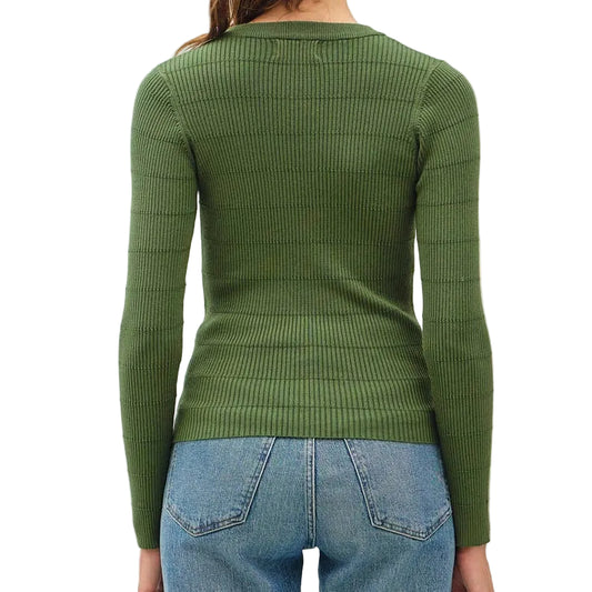 A woman viewed from behind wearing an olive green ribbed long-sleeve top, light blue jeans, and tan wedge sandals against a plain white studio background.