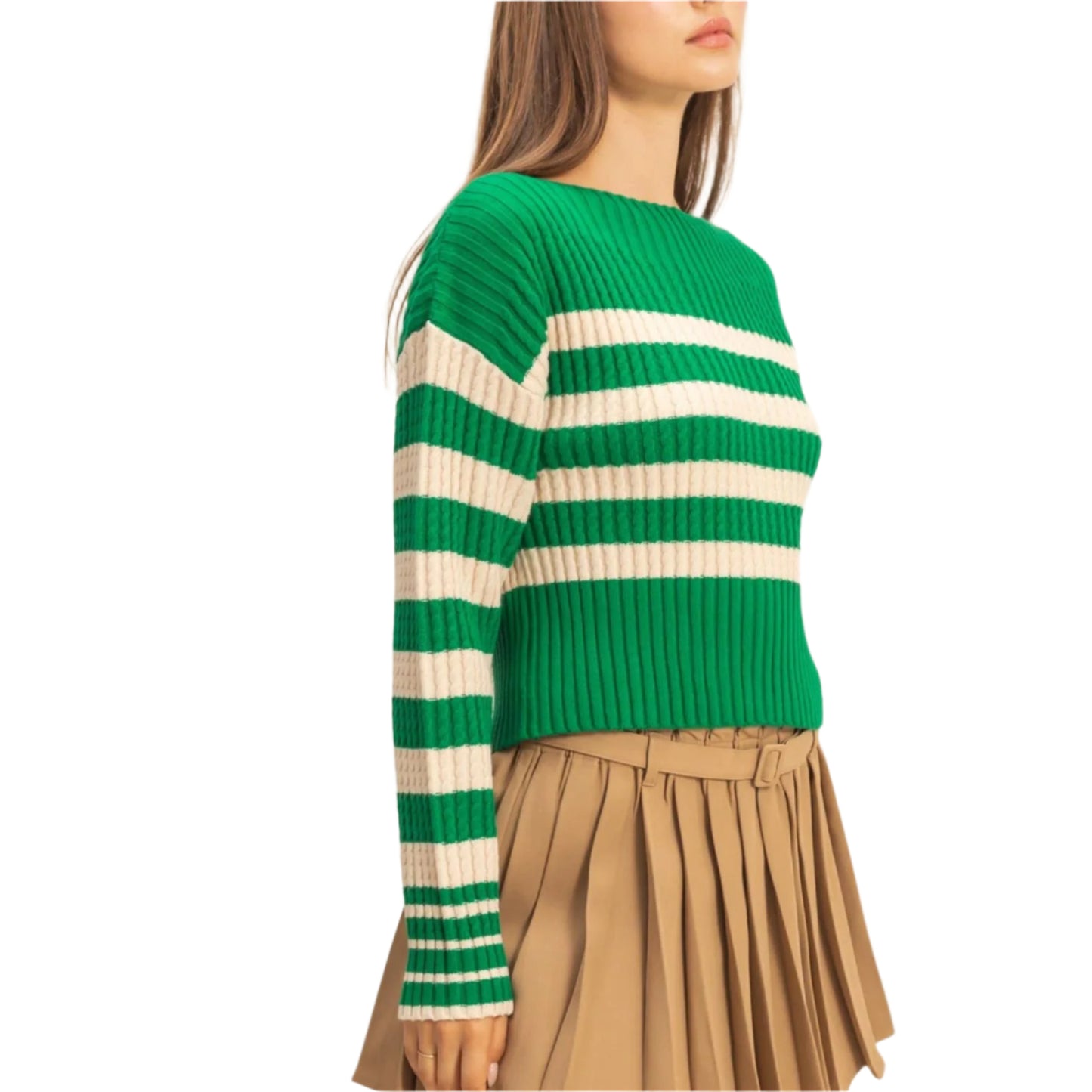 Woman wearing a green and white striped sweater with a beige pleated skirt on a beige background