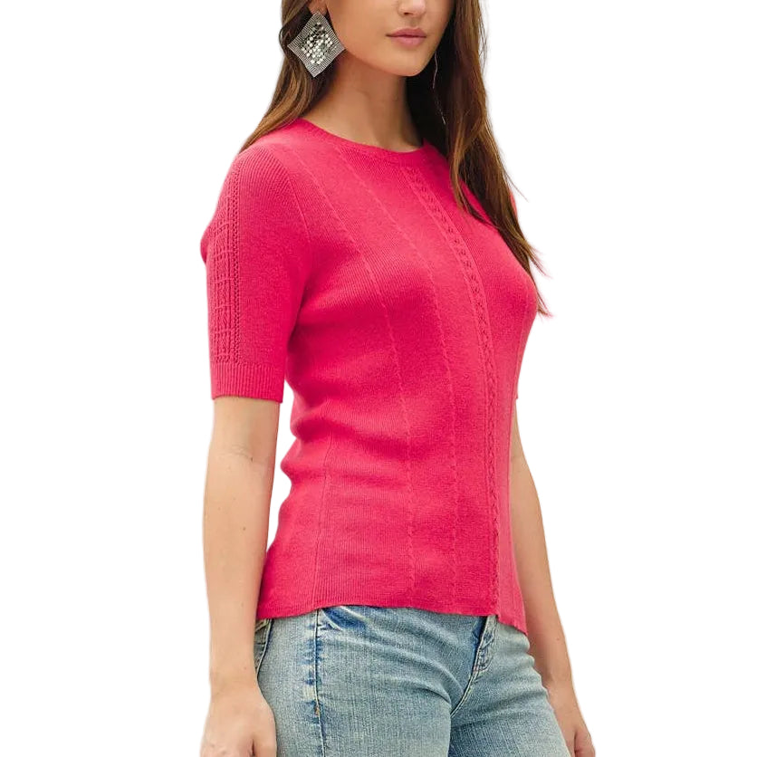 Woman wearing a bright pink top and light blue jeans on a white background