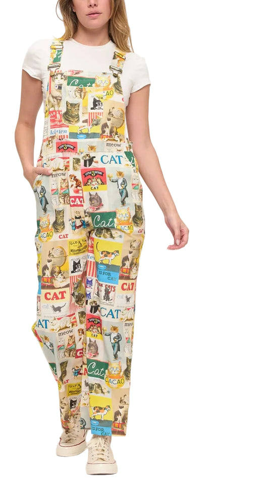 Person wearing a colorful cat-themed overalls on a white background