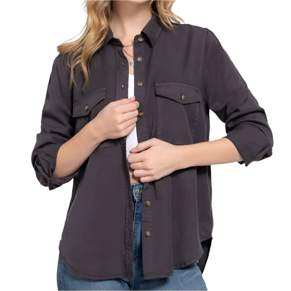 A woman wearing a button-up shirt and blue jeans on a white background