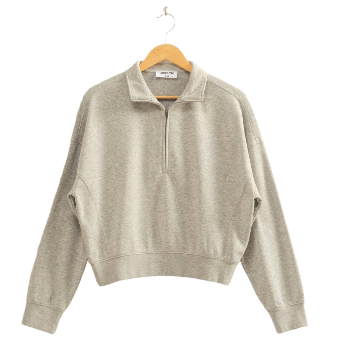 Gray sweater on a hanger against a beige wall