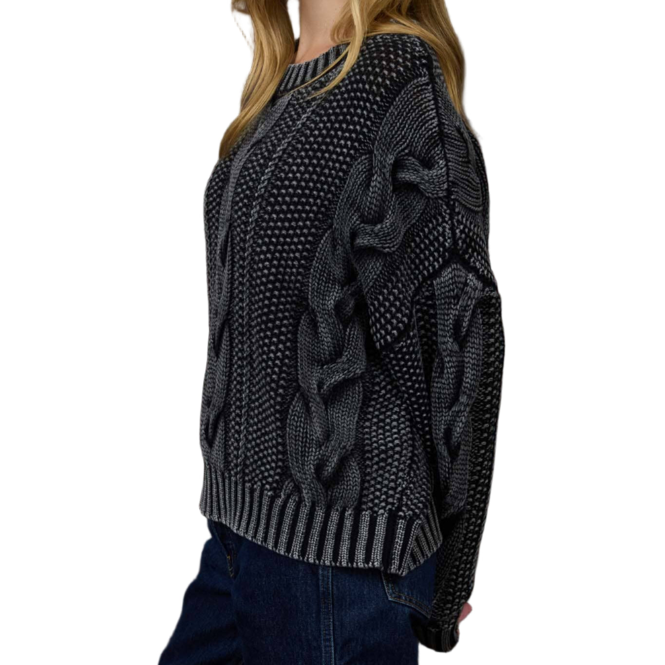 Woman wearing a dark gray cable knit sweater in an indoor setting.