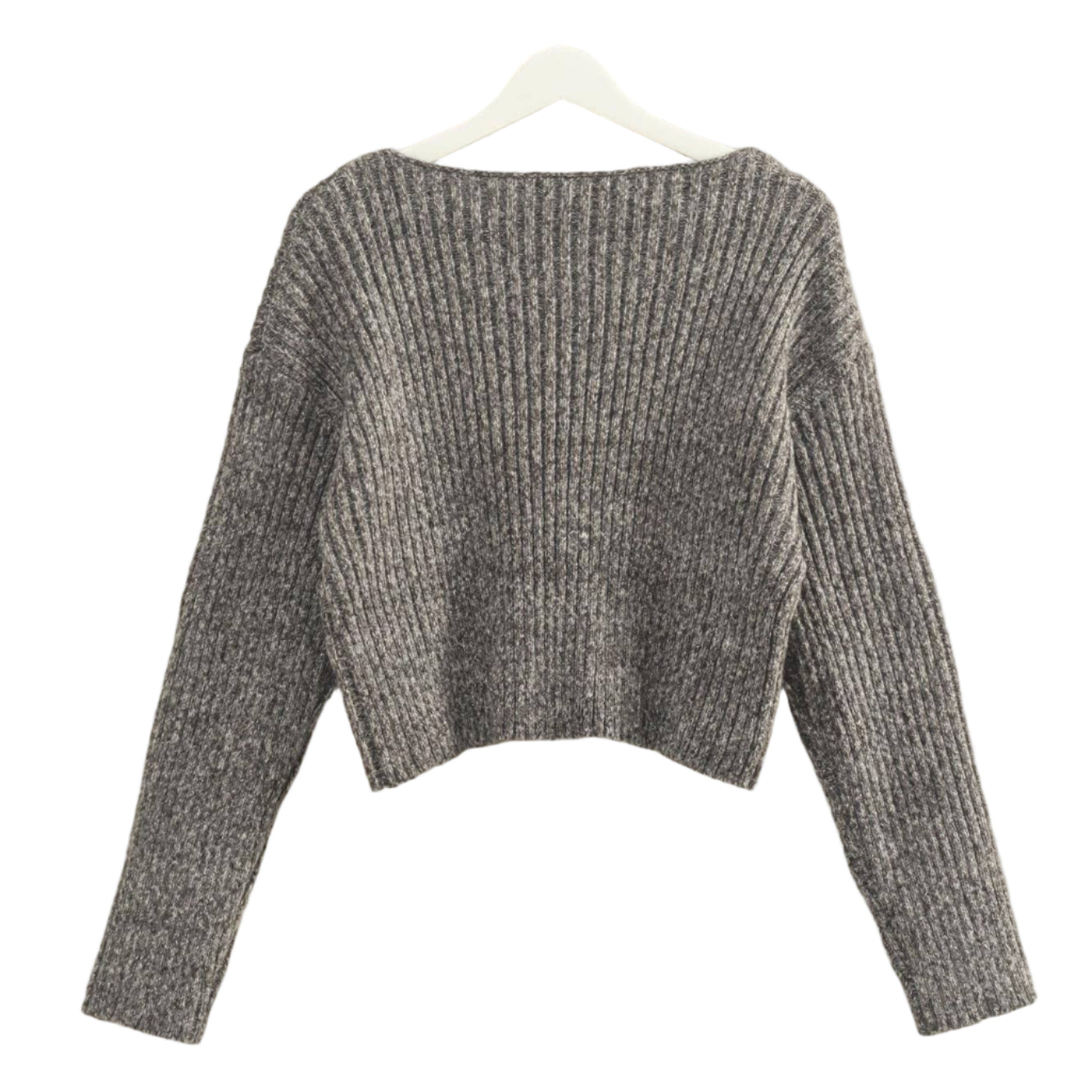 Gray knitted sweater on a hanger against a beige wall