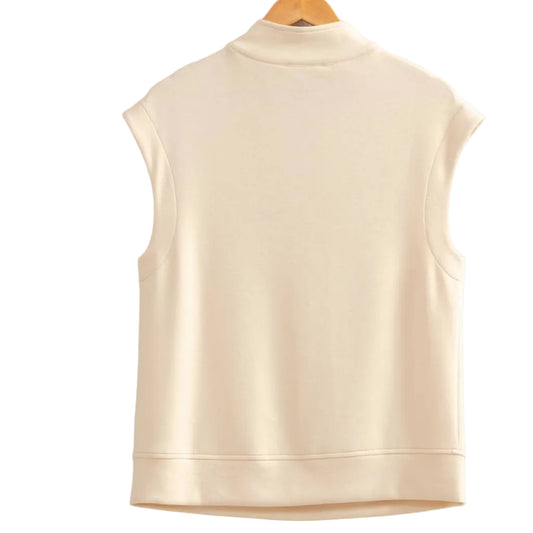 Beige vest on a hanger against a plain background