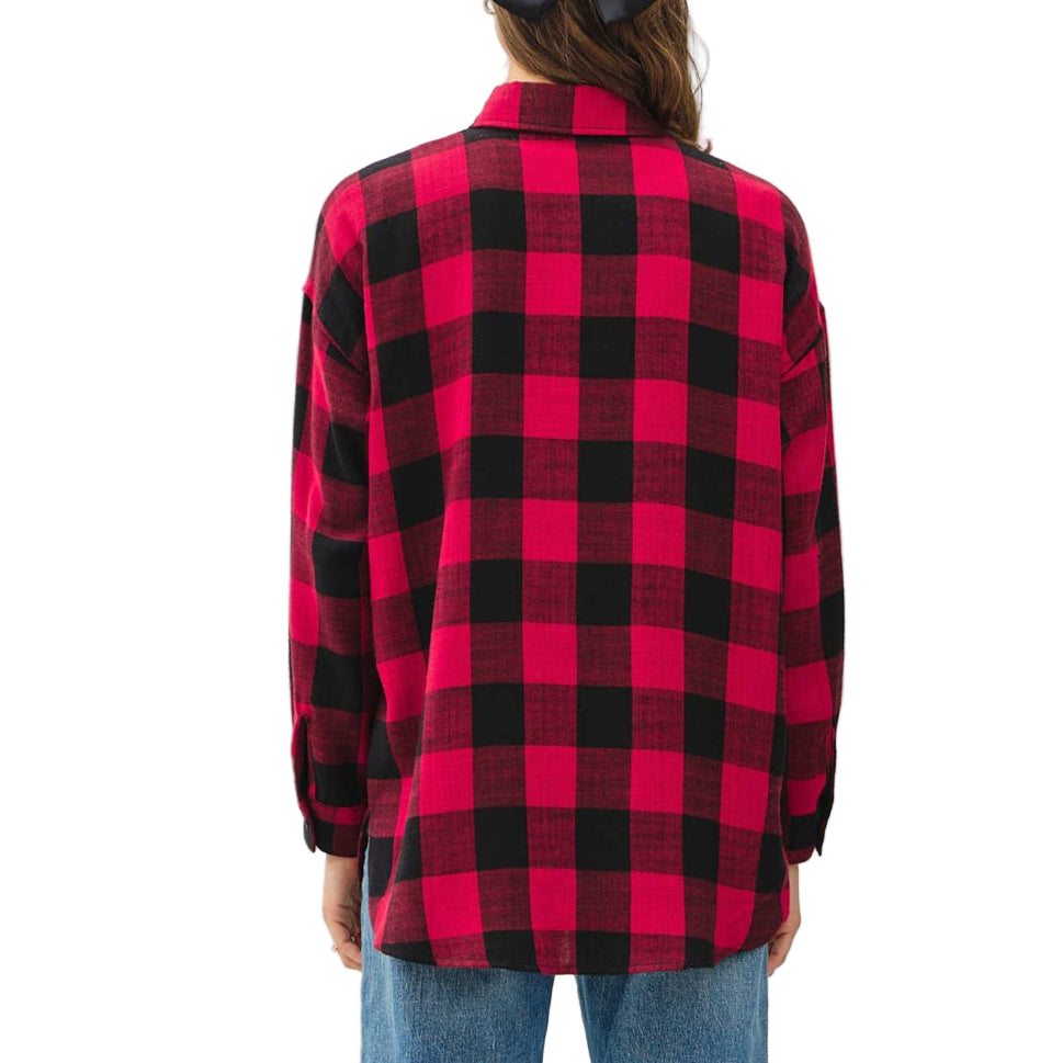 Person wearing a red and black plaid shirt and blue jeans on a white background