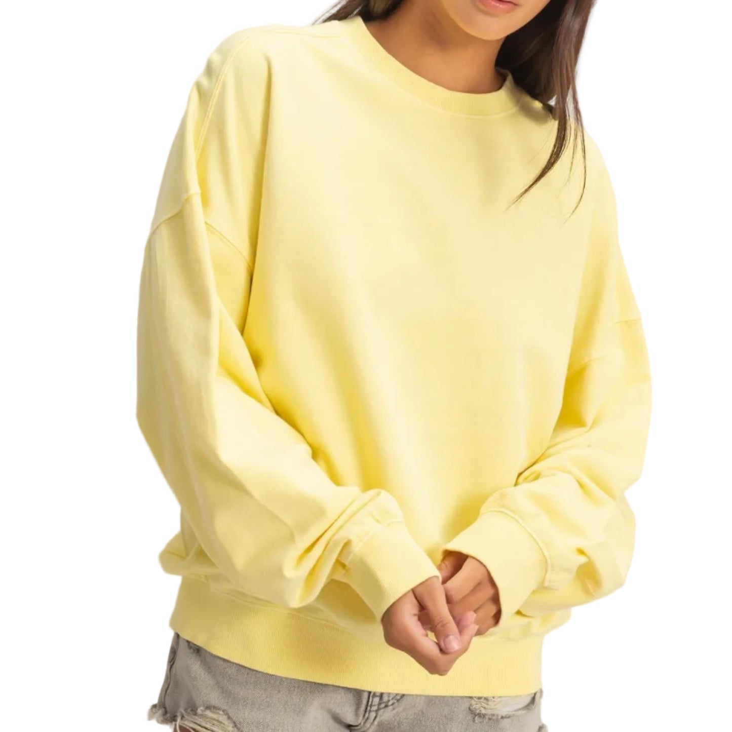 Person wearing a yellow sweatshirt and denim shorts on a plain background