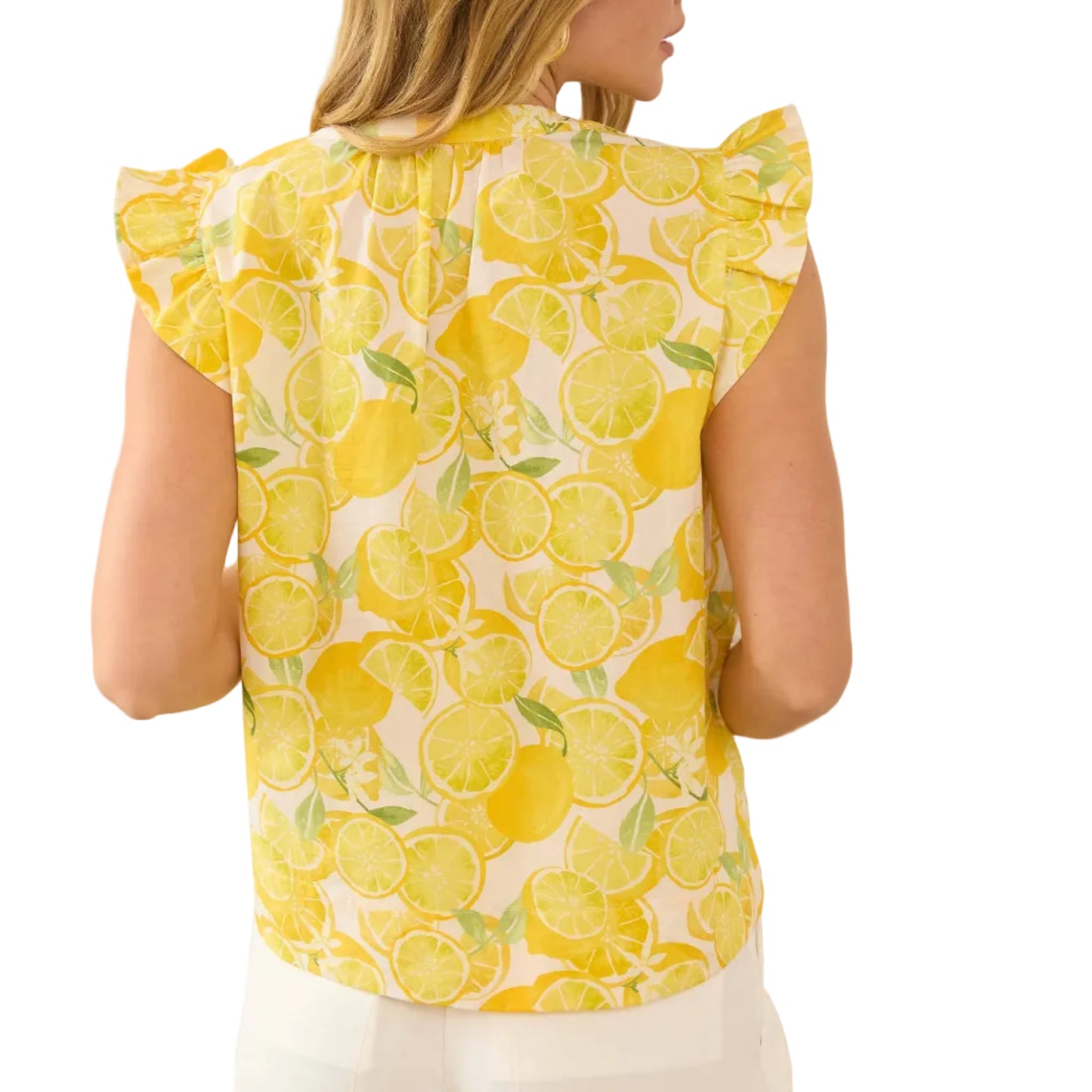 Woman wearing a yellow sleeveless top with lemon pattern indoors