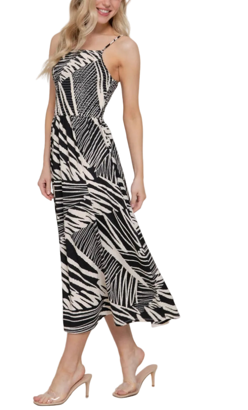 Woman wearing a black and white patterned dress against a plain background