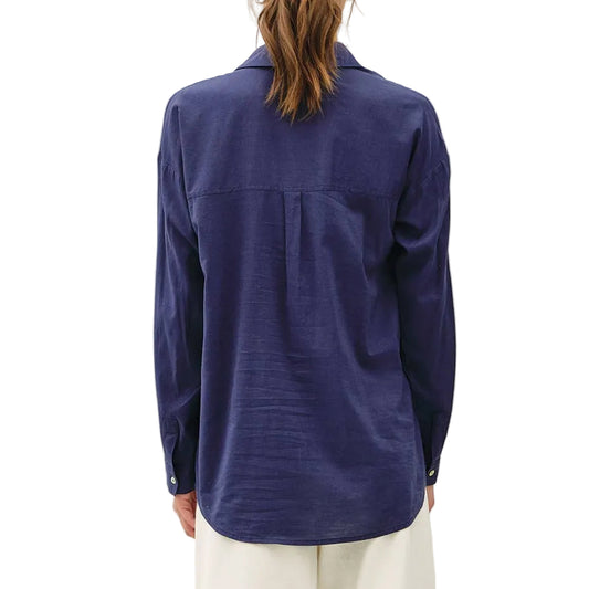 Person wearing a blue shirt and white pants on a white background