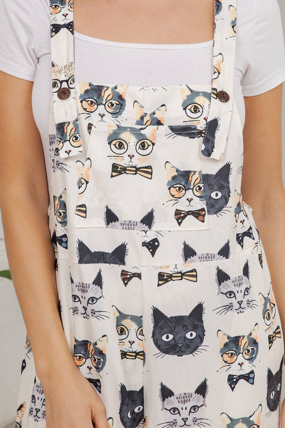 Person wearing a white apron with cat pattern