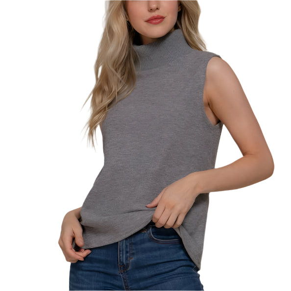 Woman wearing a gray sleeveless top and blue jeans against a beige background