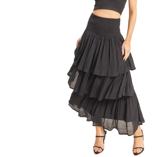 Woman wearing a black tiered skirt and top on a white background