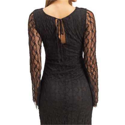 Black lace dress with sheer sleeves on a beige background