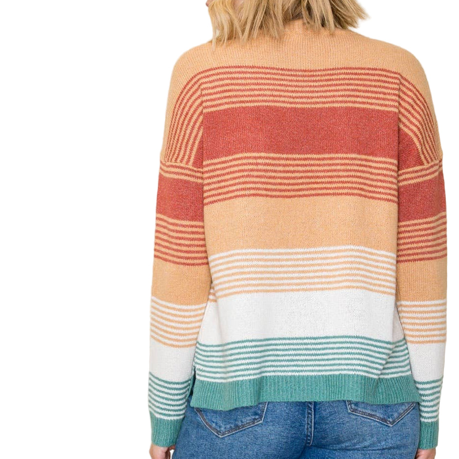 Woman wearing a colorful striped sweater with a plain background