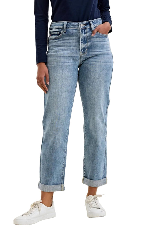 Person wearing light blue jeans on a beige background