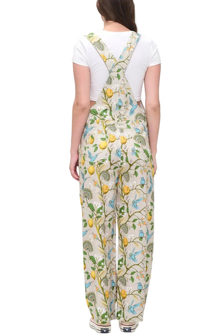 Person wearing floral overalls on a white background
