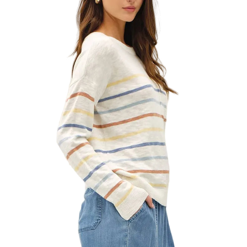 Woman wearing a striped sweater and wide-leg jeans on a white background