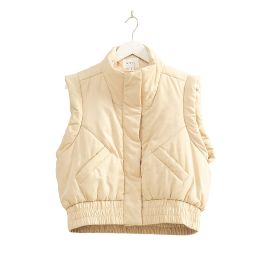 Beige puffer vest on a hanger against a plain background